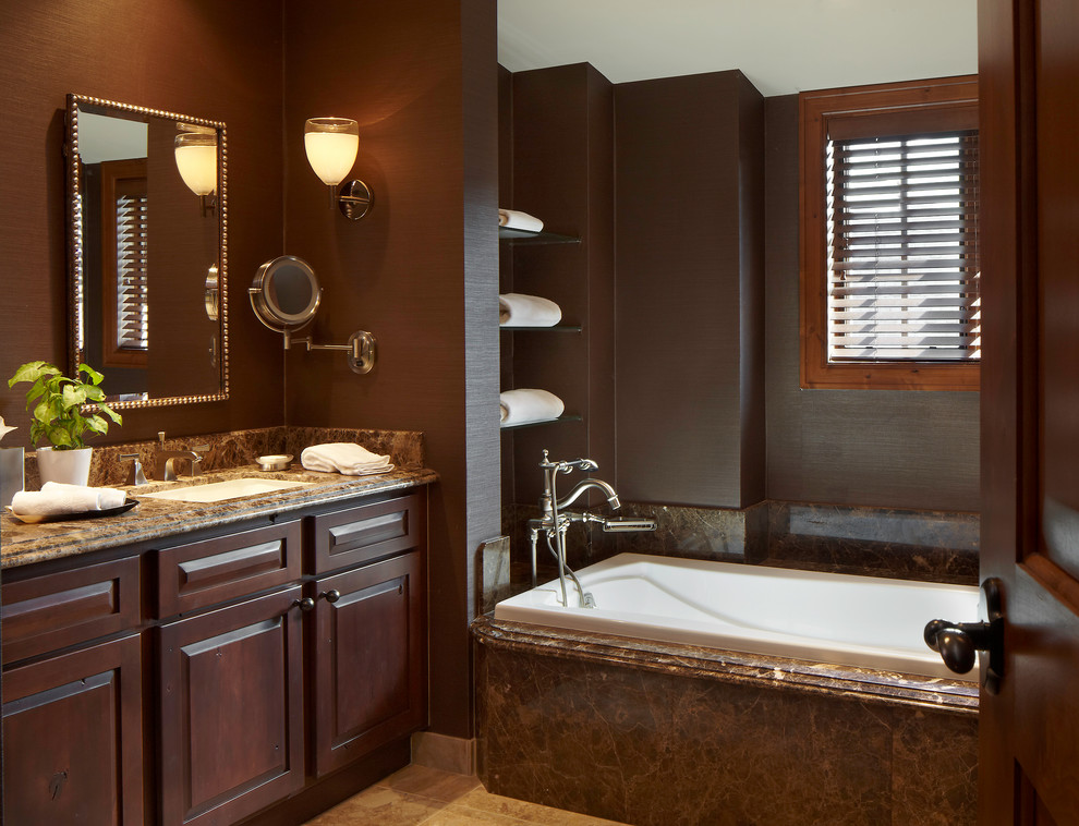 На фото: главная ванная комната в стиле рустика с фасадами с выступающей филенкой, темными деревянными фасадами, ванной в нише и коричневыми стенами с