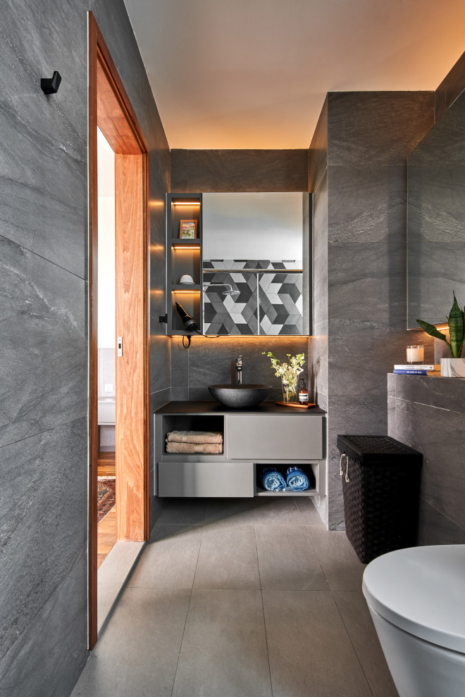 Diseño de cuarto de baño único contemporáneo con armarios con paneles lisos, puertas de armario grises, baldosas y/o azulejos grises, lavabo sobreencimera, suelo gris y encimeras grises