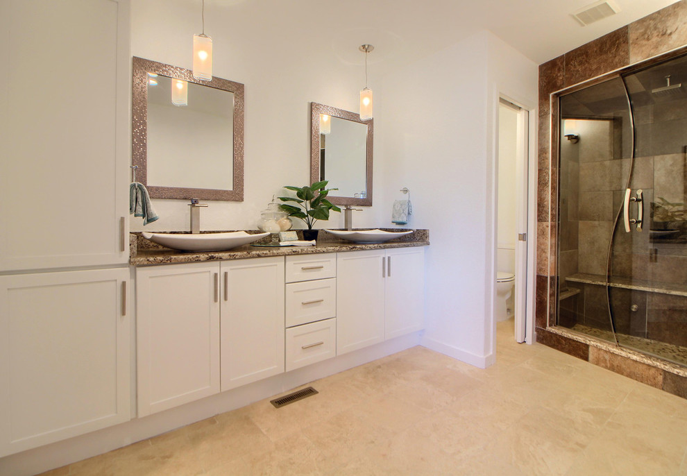 Inspiration pour une salle de bain principale design de taille moyenne avec un placard à porte shaker, des portes de placard blanches, un espace douche bain, un mur blanc, une vasque, un plan de toilette en granite et une cabine de douche à porte battante.