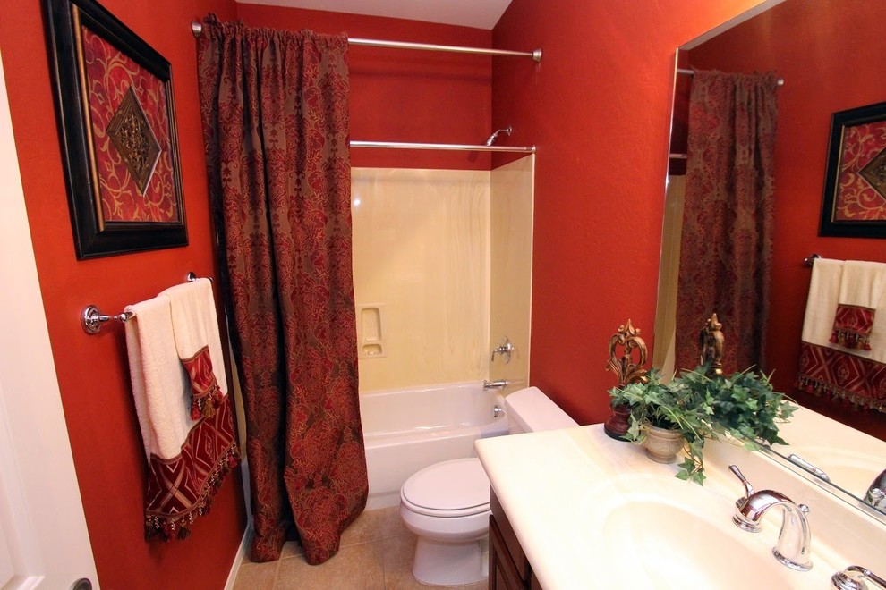 Inspiration pour une salle de bain traditionnelle avec un lavabo intégré, une baignoire en alcôve, un combiné douche/baignoire, WC à poser et un mur rouge.