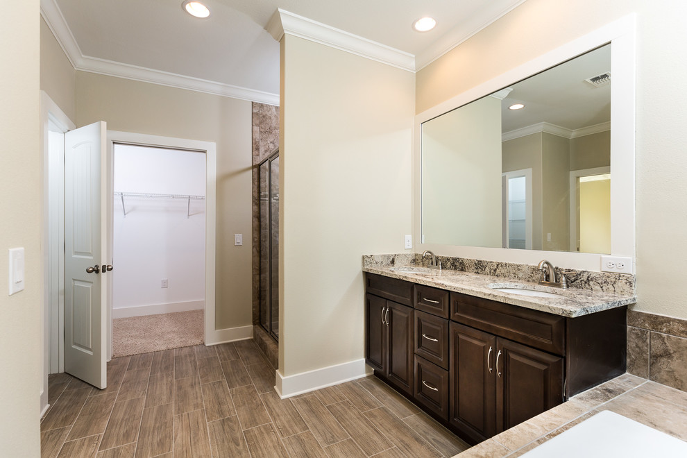 Example of a large classic master porcelain tile and beige floor bathroom design in Miami with raised-panel cabinets, brown cabinets, a two-piece toilet, beige walls, an undermount sink, granite countertops and a hinged shower door