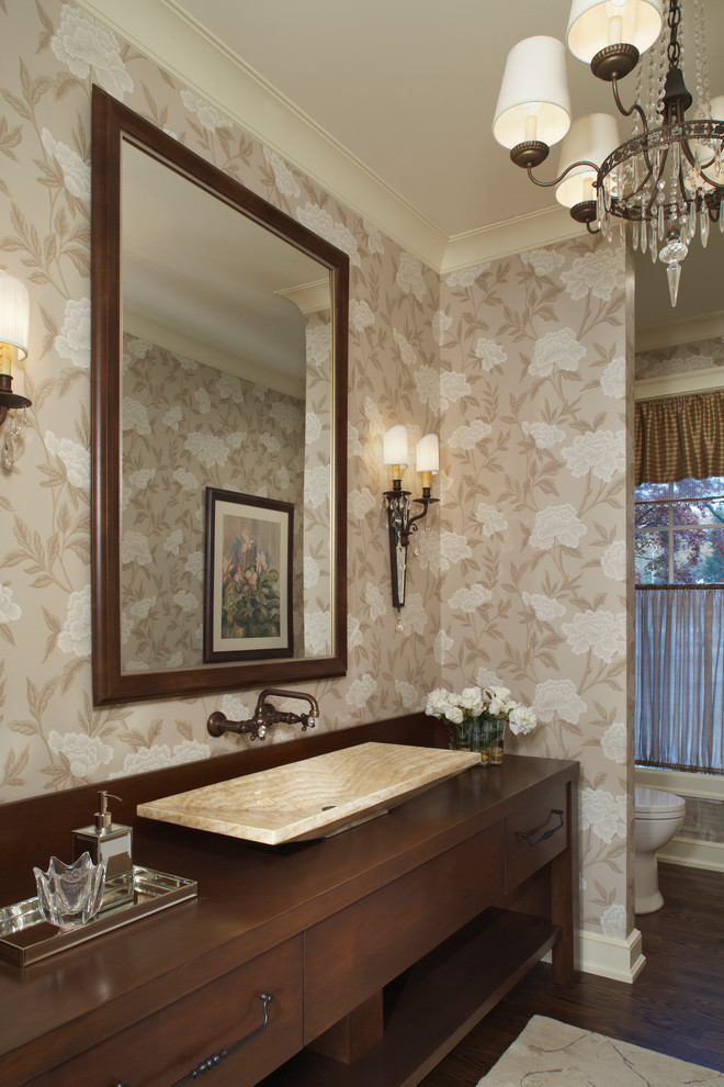 Cette photo montre une salle de bain chic en bois foncé avec une vasque, un placard à porte plane, un plan de toilette en bois, un mur beige et parquet foncé.