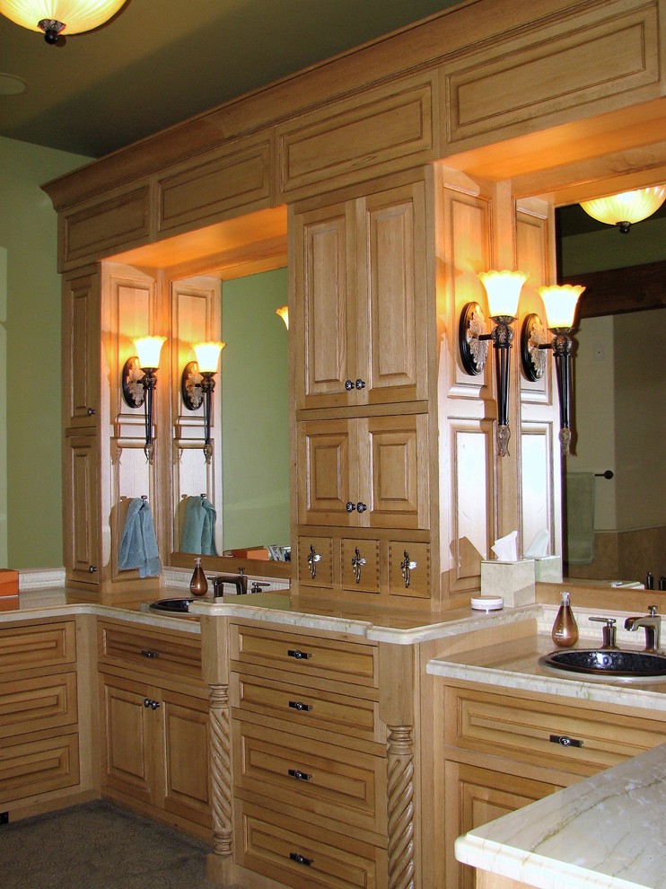 Cette image montre une grande salle de bain principale traditionnelle en bois clair avec un placard en trompe-l'oeil, WC à poser, un mur vert, un lavabo posé et un plan de toilette en marbre.