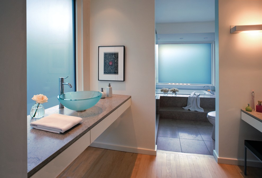 This is an example of a large contemporary ensuite bathroom in Other with a vessel sink, a built-in bath, grey tiles, flat-panel cabinets, white cabinets, a walk-in shower, a one-piece toilet, stone tiles, white walls, limestone flooring and limestone worktops.