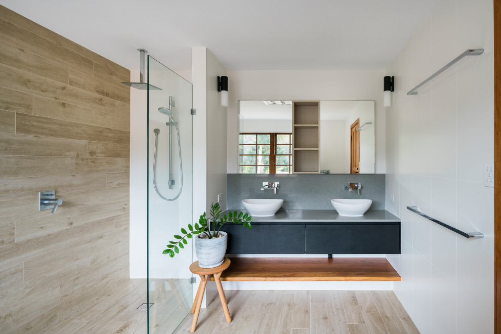 Mid-sized trendy master white tile and ceramic tile porcelain tile and brown floor bathroom photo in Brisbane with flat-panel cabinets, black cabinets, white walls, a vessel sink, quartz countertops and gray countertops