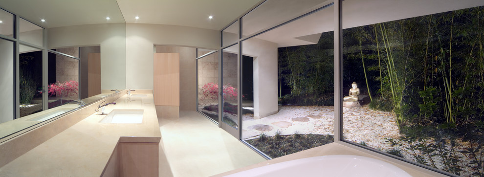 Пример оригинального дизайна: большая главная ванная комната в стиле модернизм с плоскими фасадами, белыми фасадами, накладной ванной, бежевыми стенами, полом из известняка, врезной раковиной и столешницей из известняка