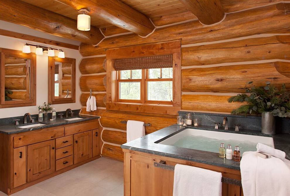 Idée de décoration pour une salle de bain principale chalet en bois brun avec un placard à porte shaker, une baignoire encastrée, un lavabo encastré et une fenêtre.