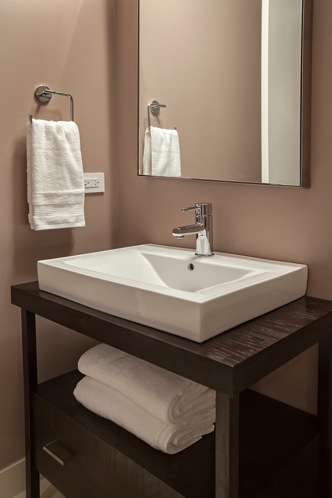 Immagine di una stanza da bagno minimal con lavabo a bacinella, ante in legno bruno e top in legno