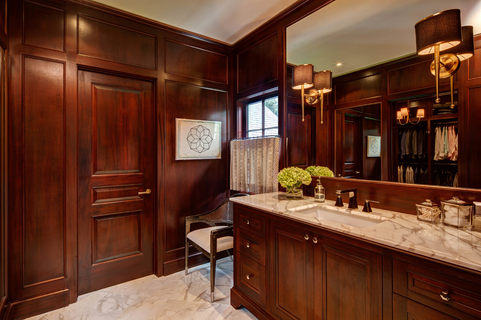 Inredning av ett klassiskt en-suite badrum, med skåp i mörkt trä, bruna väggar, ett undermonterad handfat, beiget golv, marmorgolv, marmorbänkskiva och luckor med infälld panel