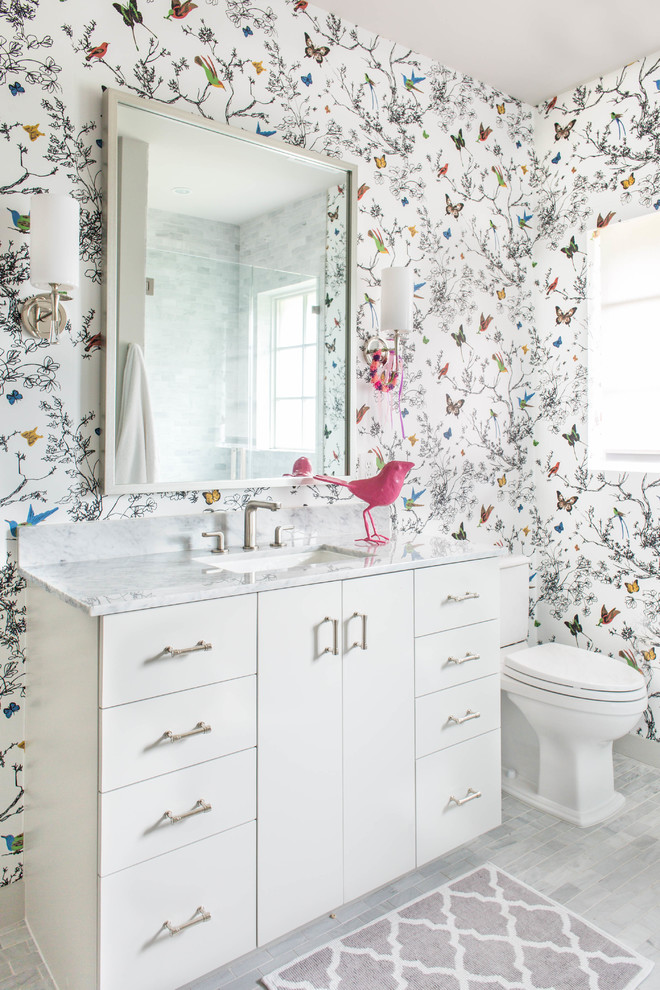 Bathroom - contemporary kids' gray floor bathroom idea in Houston with flat-panel cabinets, white cabinets, a two-piece toilet, multicolored walls and an undermount sink
