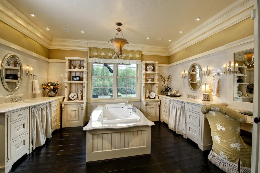 Example of a classic drop-in bathtub design in Denver with open cabinets