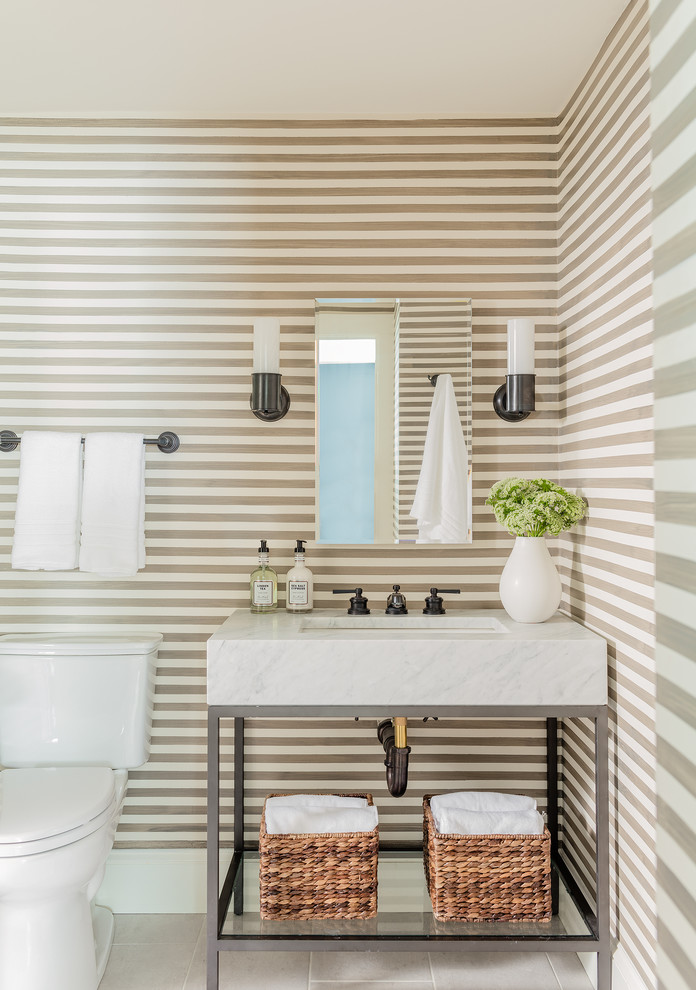 Diseño de cuarto de baño costero con armarios abiertos, paredes multicolor, lavabo bajoencimera, suelo gris, encimeras blancas y espejo con luz