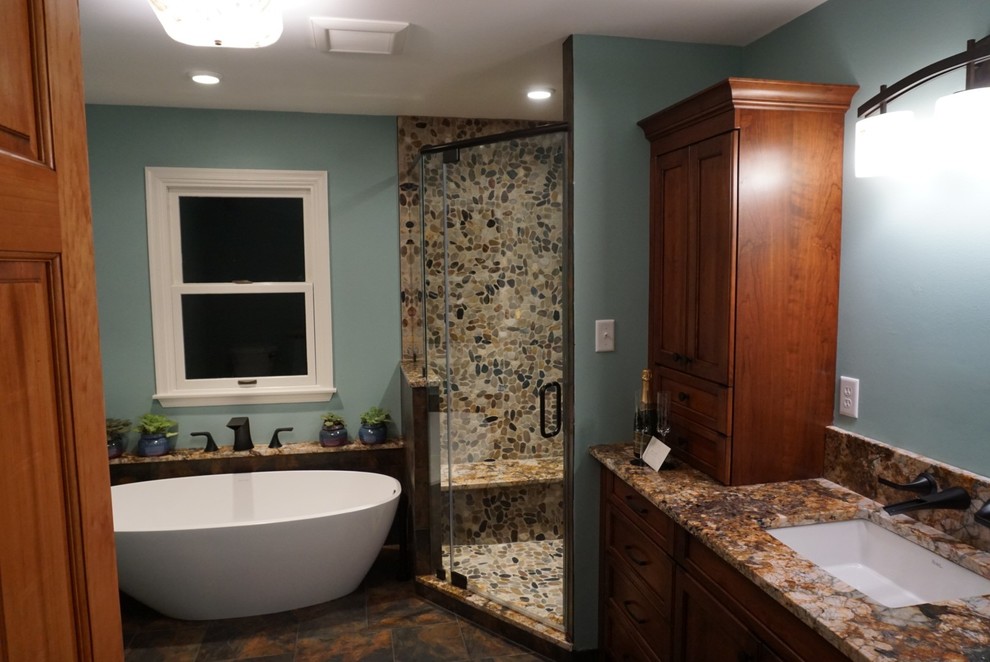 Exemple d'une grande salle de bain principale moderne en bois brun avec un placard avec porte à panneau surélevé, une baignoire indépendante, une douche d'angle, un carrelage gris, du carrelage en ardoise, un mur bleu, un sol en ardoise, un lavabo encastré, un plan de toilette en quartz, un sol gris et une cabine de douche à porte battante.