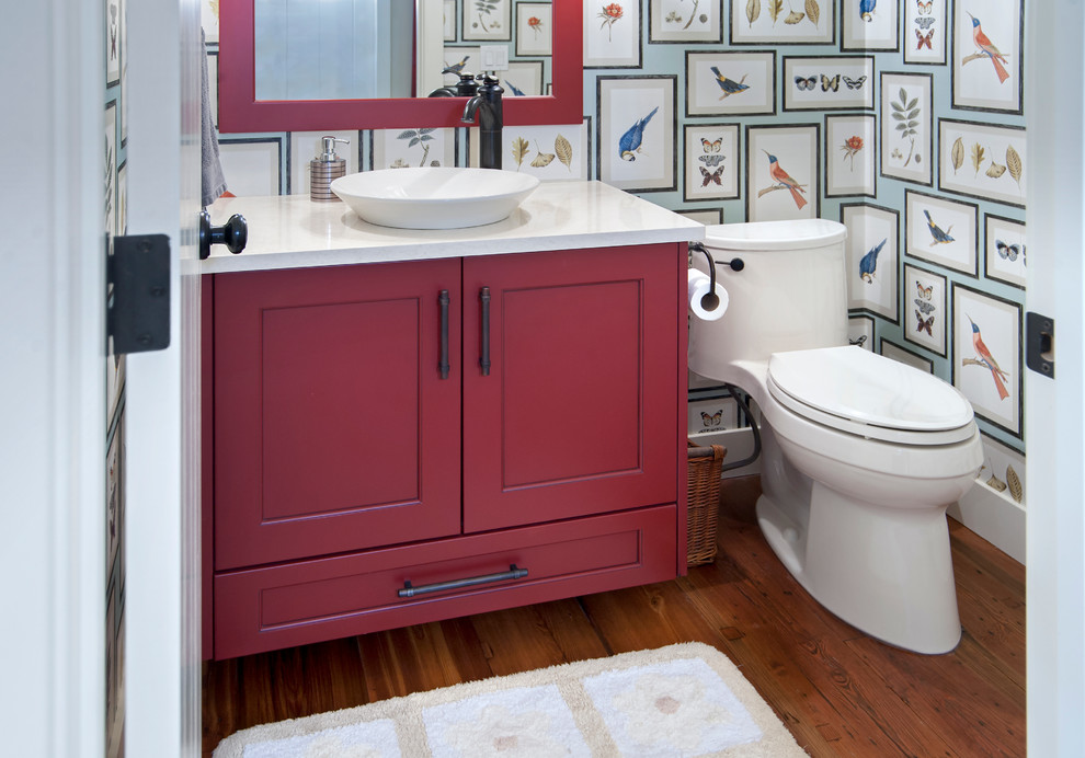 Foto på ett maritimt badrum, med skåp i shakerstil, röda skåp, ett hörnbadkar, en dusch/badkar-kombination, en toalettstol med separat cisternkåpa, blå kakel, vit kakel, tunnelbanekakel, beige väggar, klinkergolv i keramik, ett undermonterad handfat och bänkskiva i akrylsten