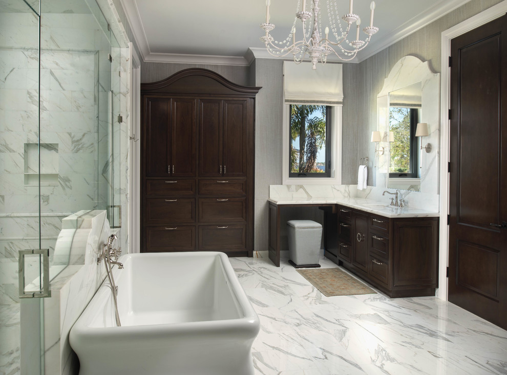 This is an example of a large traditional ensuite wet room bathroom in Miami with shaker cabinets, dark wood cabinets, a freestanding bath, a submerged sink, white floors, a hinged door, white worktops, white walls, marble flooring, marble worktops, an enclosed toilet, double sinks and a built in vanity unit.