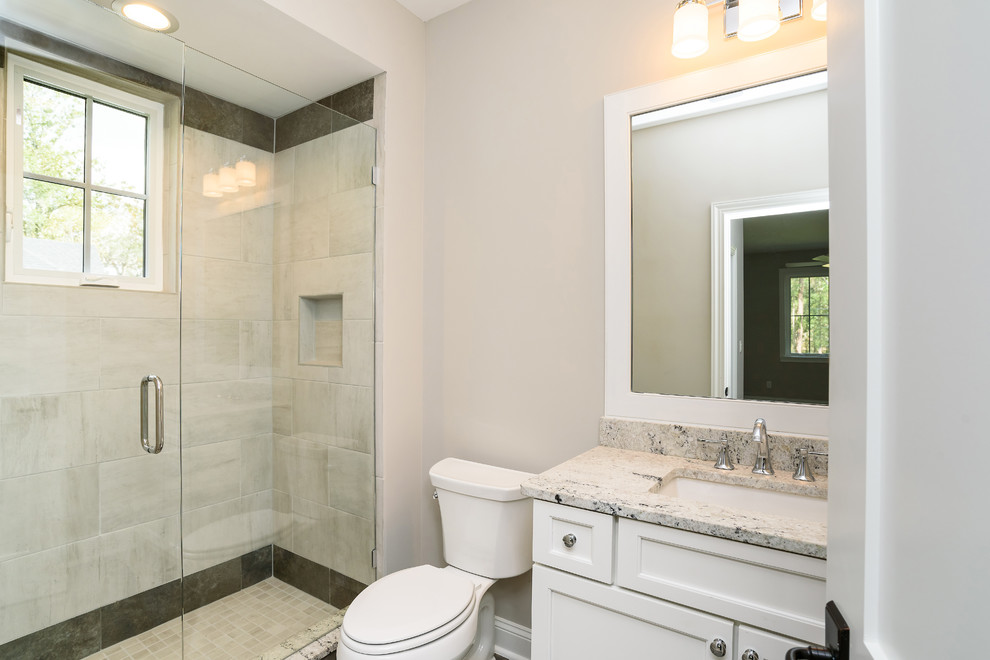 This is an example of a small classic shower room bathroom in Jacksonville with shaker cabinets, white cabinets, an alcove shower, a one-piece toilet, grey tiles, porcelain tiles, beige walls, a submerged sink and granite worktops.