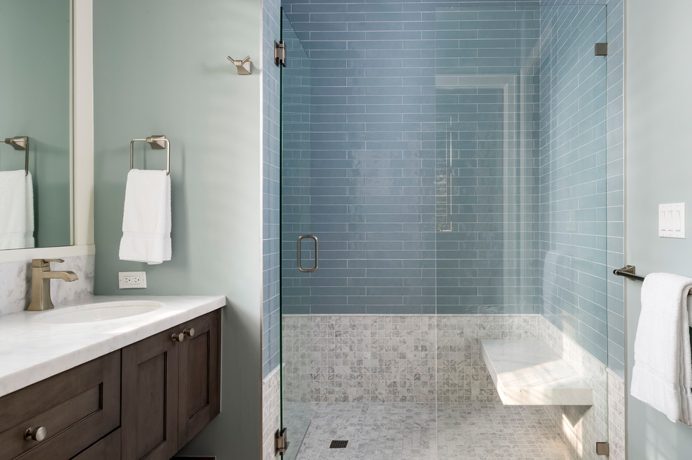 На фото: ванная комната в стиле неоклассика (современная классика) с фасадами с утопленной филенкой, коричневыми фасадами, душем в нише, синей плиткой, плиткой кабанчик, синими стенами, полом из травертина, монолитной раковиной, мраморной столешницей, бежевым полом и душем с распашными дверями