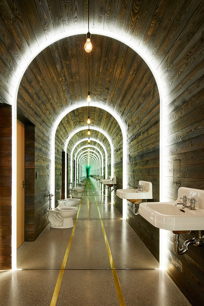 Immagine di una stanza da bagno industriale con pareti marroni, lavabo sospeso e pavimento grigio
