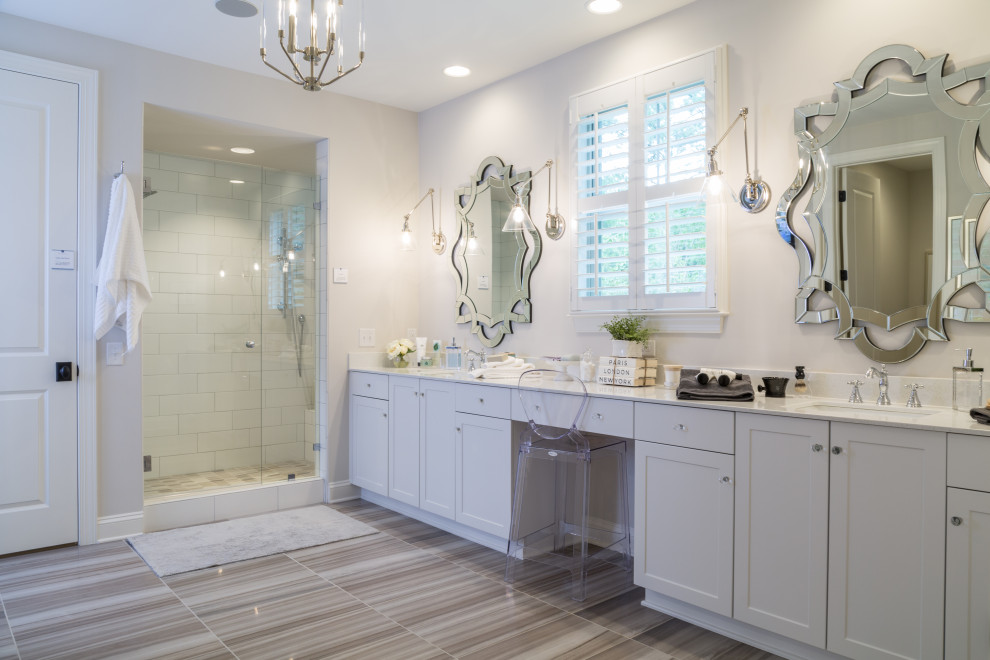 На фото: большая главная ванная комната в стиле неоклассика (современная классика) с фасадами в стиле шейкер, серыми фасадами, душем в нише, белыми стенами, врезной раковиной, серым полом и белой столешницей