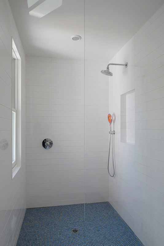 Cette image montre une petite douche en alcôve minimaliste pour enfant avec un carrelage bleu, mosaïque, un mur blanc, un sol en carrelage de céramique et un lavabo suspendu.