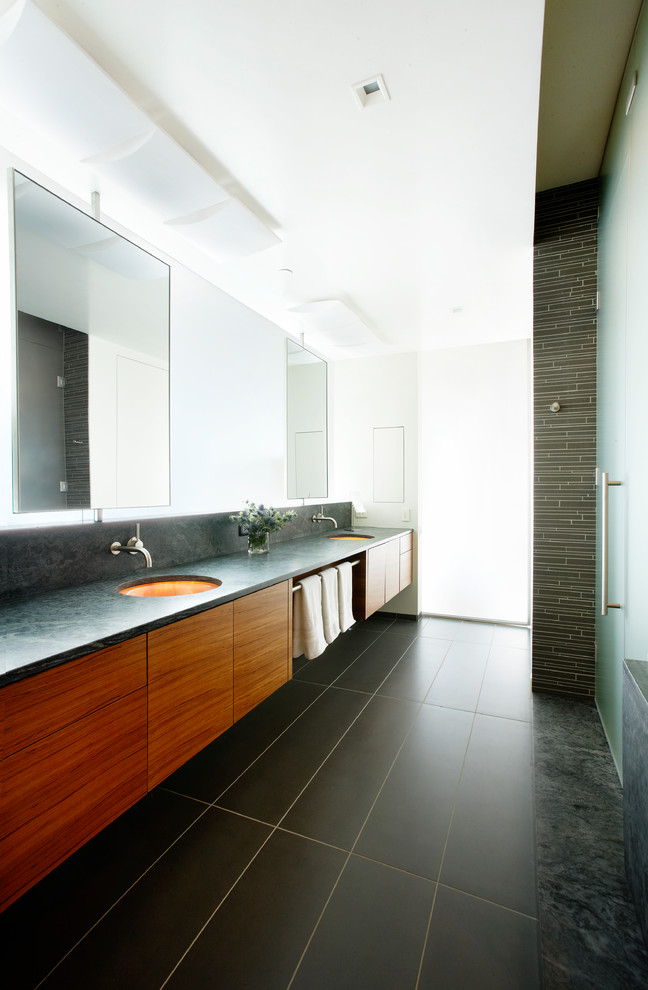 Esempio di una stanza da bagno contemporanea con lavabo sottopiano, ante lisce, ante in legno scuro, doccia alcova, piastrelle nere e top grigio