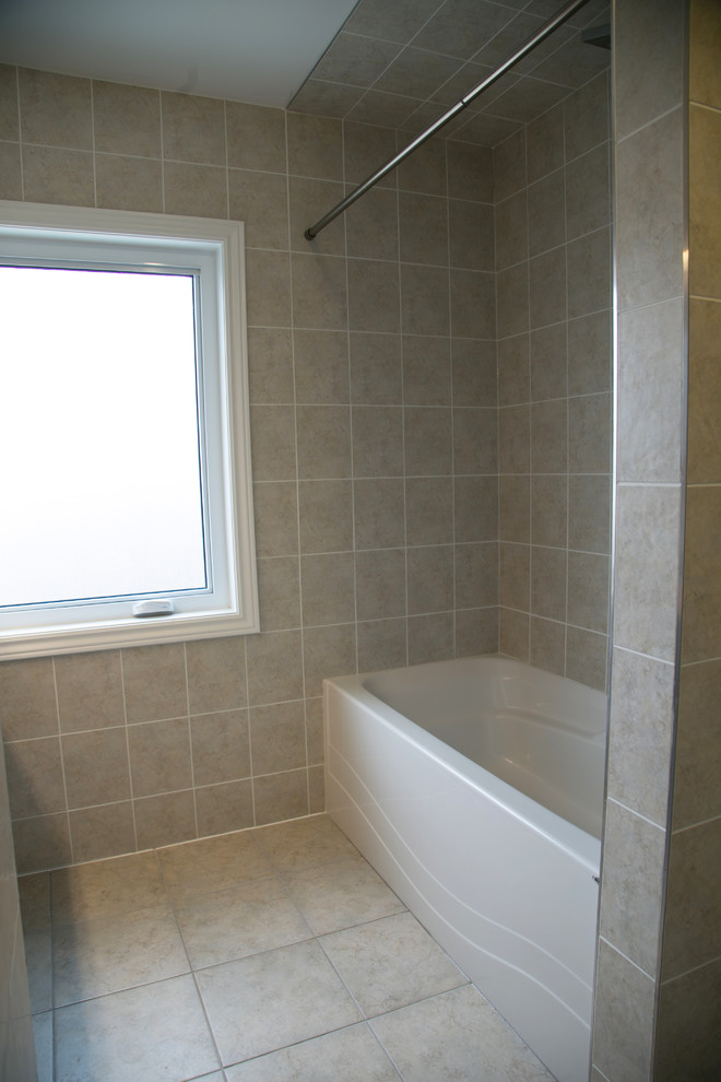 Photo of a medium sized traditional bathroom with shaker cabinets, brown cabinets, an alcove bath, a shower/bath combination, a one-piece toilet, beige tiles, beige walls, a built-in sink, beige floors and a shower curtain.