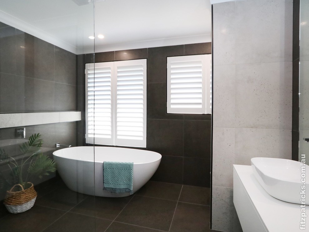 Exempel på ett modernt vit vitt badrum, med ett fristående badkar, grå kakel, grå väggar och grått golv
