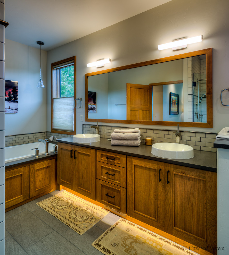 Bild på ett stort funkis en-suite badrum, med ett fristående handfat, luckor med profilerade fronter, skåp i mellenmörkt trä, ett platsbyggt badkar, beige kakel, bänkskiva i kvartsit, keramikplattor, beige väggar och klinkergolv i keramik