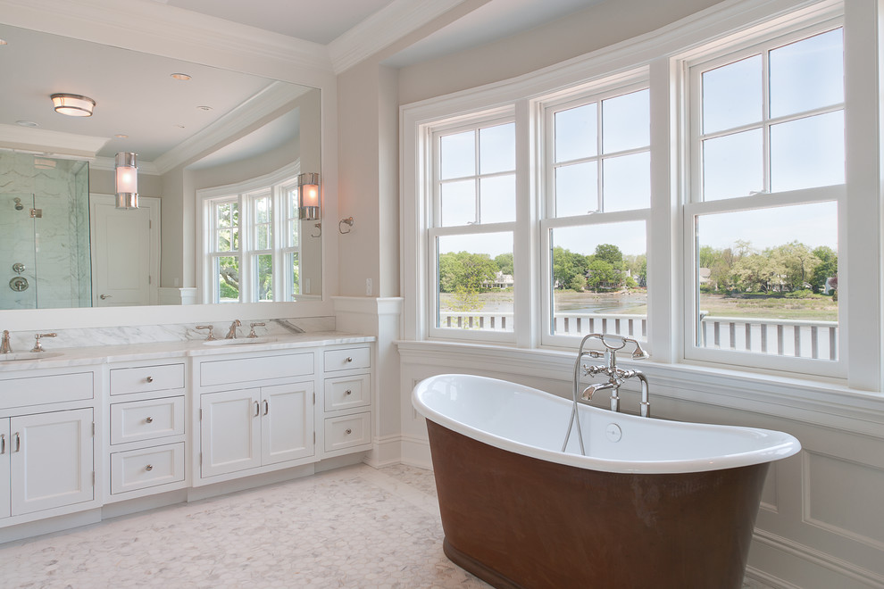 Idéer för att renovera ett stort vintage en-suite badrum, med luckor med profilerade fronter, vita skåp, ett fristående badkar, en dusch i en alkov, vit kakel, stenkakel, beige väggar, marmorgolv, ett undermonterad handfat och marmorbänkskiva