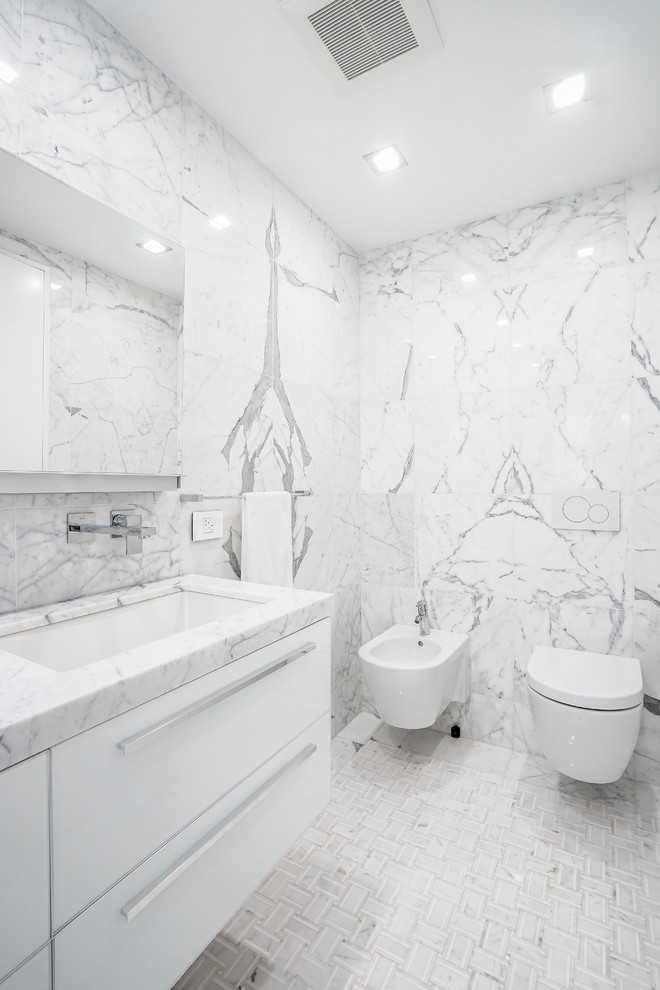 Exempel på ett stort modernt vit vitt en-suite badrum, med luckor med glaspanel, vita skåp, ett platsbyggt badkar, en öppen dusch, en vägghängd toalettstol, svart och vit kakel, stenhäll, vita väggar, marmorgolv, ett nedsänkt handfat, marmorbänkskiva, vitt golv och dusch med gångjärnsdörr