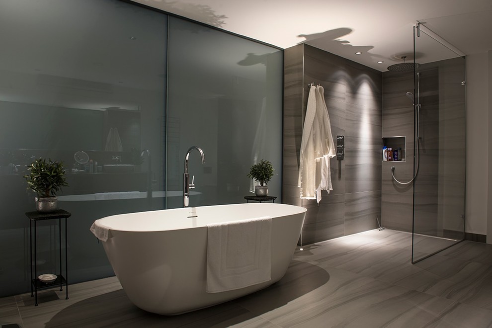 Exempel på ett stort modernt badrum för barn, med ett fristående badkar, en dubbeldusch, grå kakel, grå väggar, klinkergolv i porslin, grått golv och med dusch som är öppen