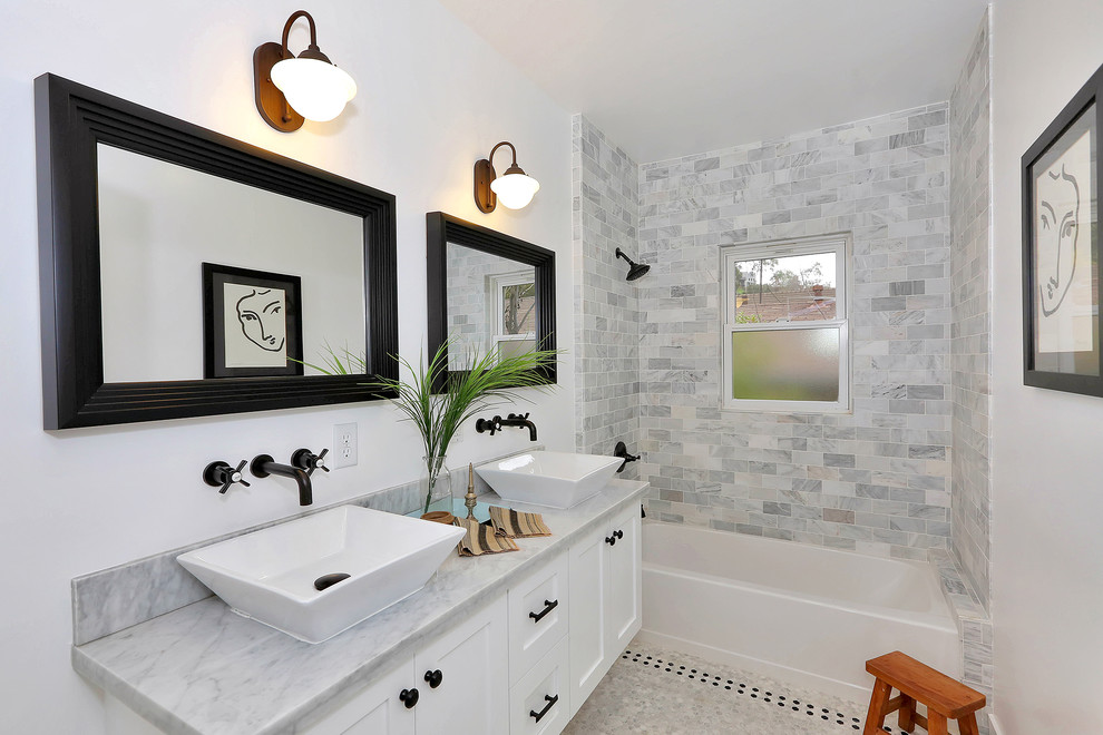 Immagine di una stanza da bagno chic con lavabo a bacinella, ante in stile shaker, ante bianche, vasca ad alcova, vasca/doccia e piastrelle grigie