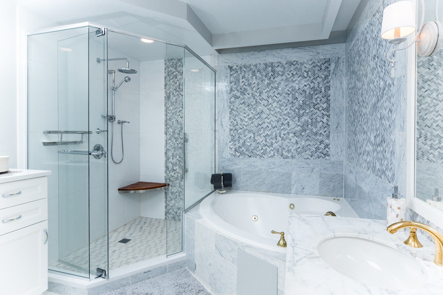 Пример оригинального дизайна: большая главная ванная комната в классическом стиле с фасадами в стиле шейкер, белыми фасадами, угловой ванной, угловым душем, раздельным унитазом, белой плиткой, керамогранитной плиткой, серыми стенами, полом из керамогранита, врезной раковиной, мраморной столешницей, белым полом и душем с распашными дверями