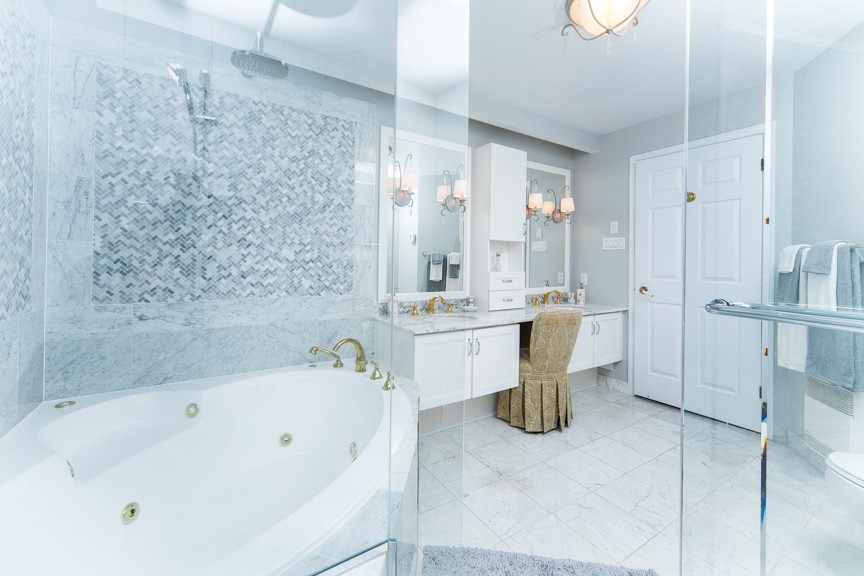 Large classic ensuite bathroom in Ottawa with shaker cabinets, white cabinets, a corner bath, a corner shower, a two-piece toilet, white tiles, porcelain tiles, grey walls, porcelain flooring, a submerged sink, marble worktops, white floors and a hinged door.