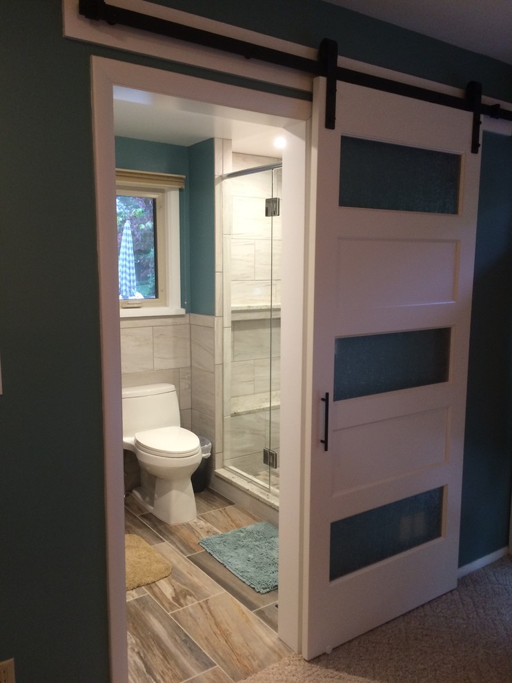 Idées déco pour une petite salle de bain classique avec WC à poser, un carrelage gris, des carreaux de porcelaine, un mur bleu, un sol en carrelage de porcelaine, un sol marron et une cabine de douche à porte coulissante.