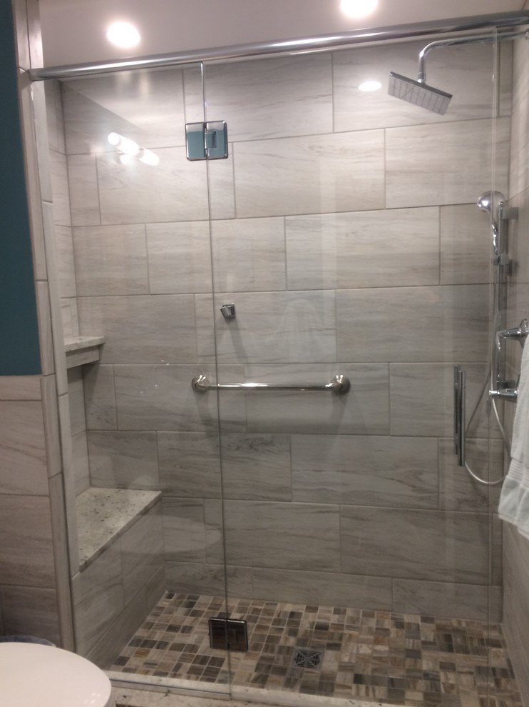 Cette image montre une petite salle de bain traditionnelle avec un carrelage gris, des carreaux de porcelaine et une cabine de douche à porte coulissante.