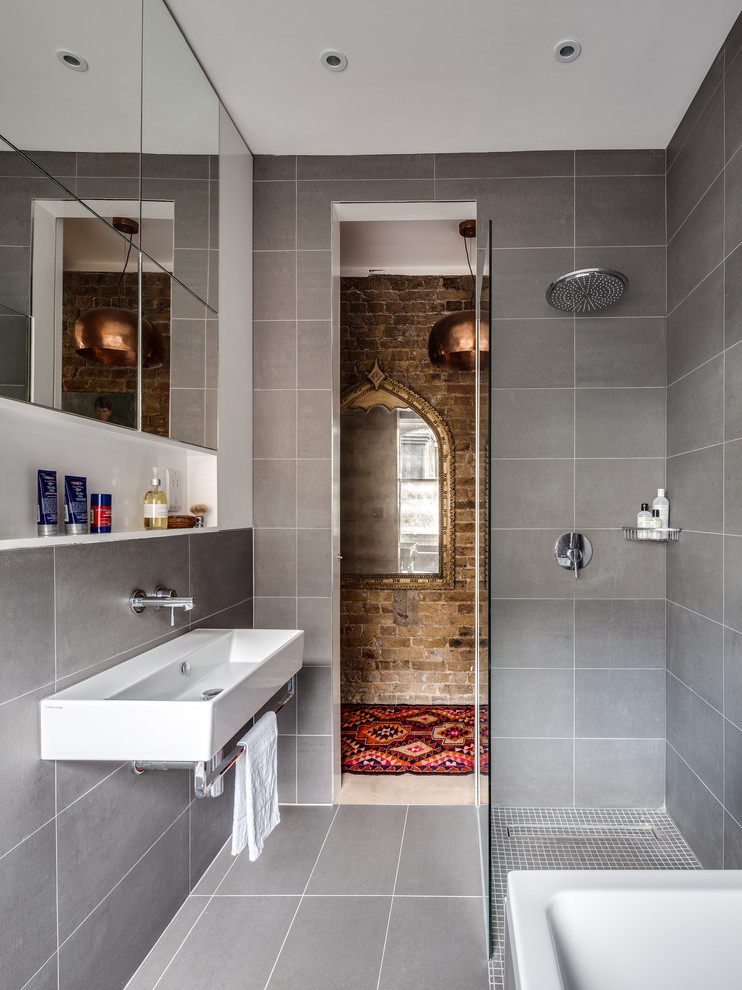 На фото: ванная комната в современном стиле с открытым душем, серой плиткой, серыми стенами, раковиной с несколькими смесителями и открытым душем