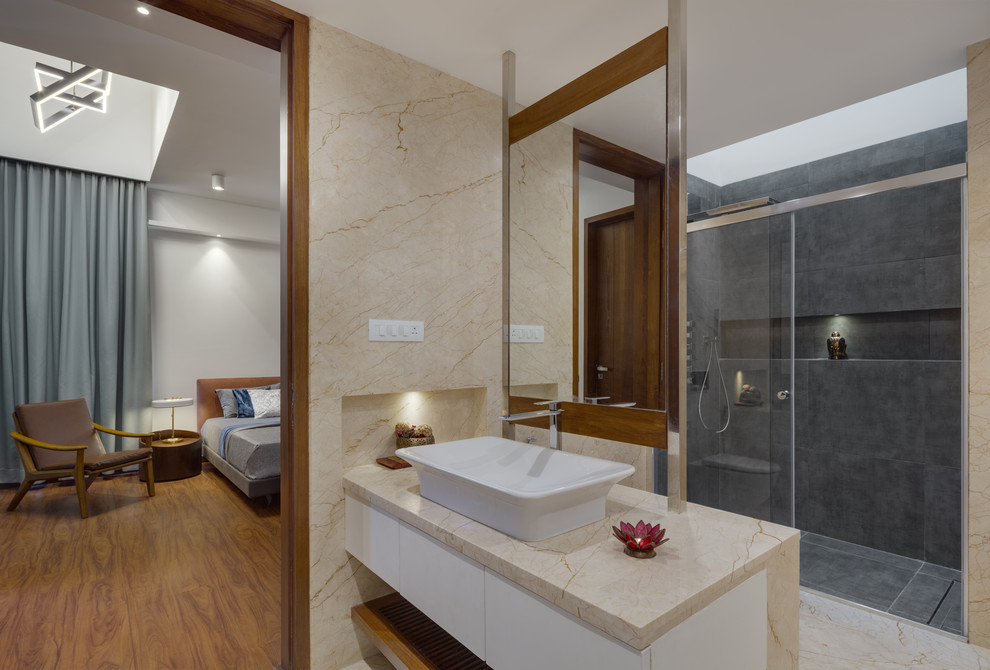 Photo of a contemporary bathroom in Bengaluru with flat-panel cabinets, white cabinets, an alcove shower, grey tiles, a vessel sink, beige floors, a sliding door and beige worktops.