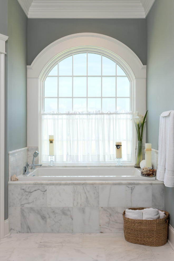 Cette image montre une grande douche en alcôve design avec une baignoire posée, WC à poser, un carrelage gris, des carreaux de porcelaine, un mur vert, un sol en marbre, un sol blanc et une cabine de douche à porte battante.