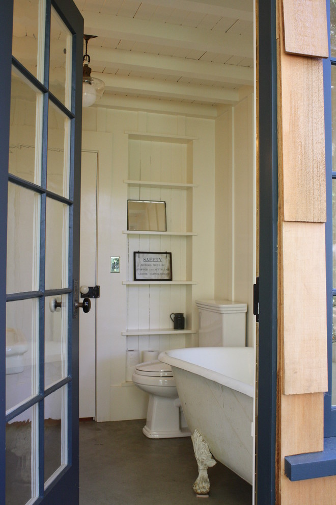 Cette image montre une salle de bain design en bois brun de taille moyenne avec un placard sans porte, une baignoire sur pieds, WC séparés, un carrelage blanc, un carrelage métro, un mur blanc, un sol en galet, un lavabo encastré, un plan de toilette en marbre, un sol blanc et une cabine de douche à porte battante.