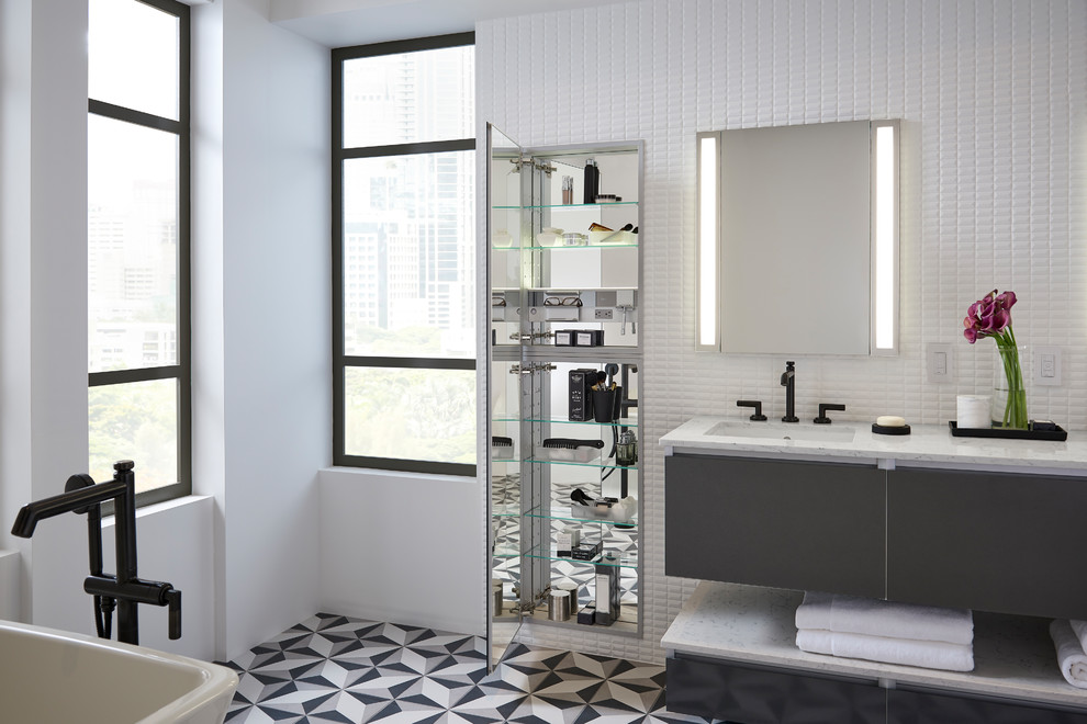 Example of a large minimalist master white tile and ceramic tile ceramic tile and multicolored floor freestanding bathtub design in Chicago with glass-front cabinets, gray cabinets, white walls, an undermount sink and quartz countertops