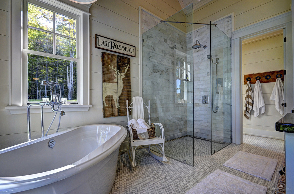 На фото: главная ванная комната в стиле рустика с отдельно стоящей ванной, угловым душем, плиткой мозаикой, бежевыми стенами, серой плиткой и окном с