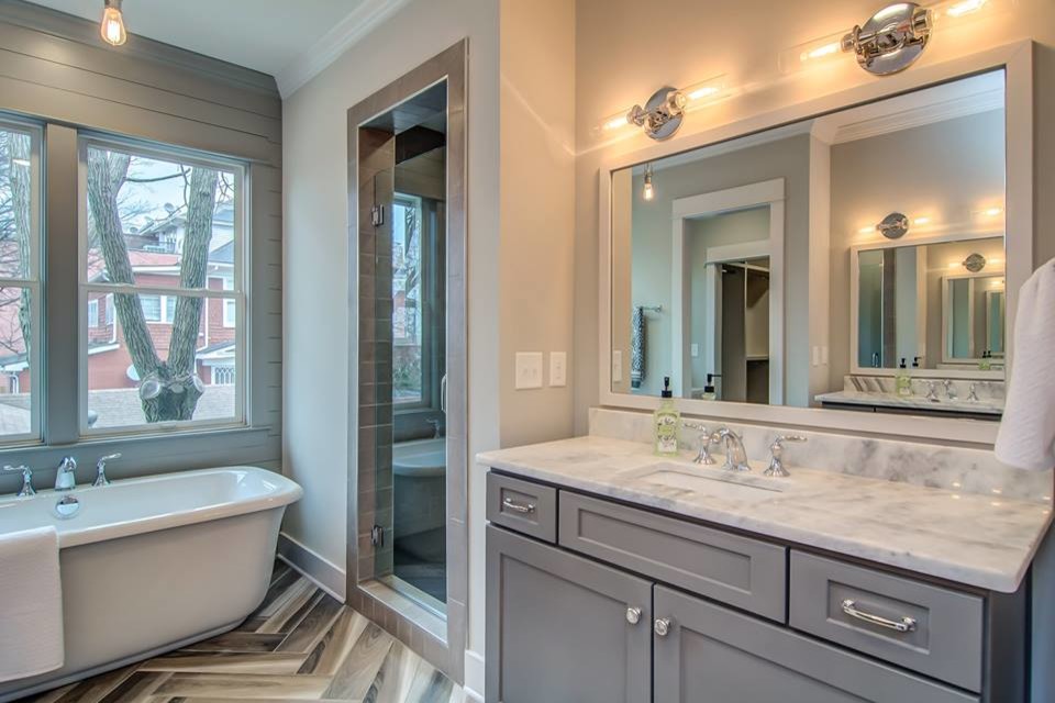 Inspiration for a large traditional ensuite bathroom in Raleigh with shaker cabinets, grey cabinets, a freestanding bath, an alcove shower, grey walls, porcelain flooring, a submerged sink, engineered stone worktops, multi-coloured floors and a hinged door.