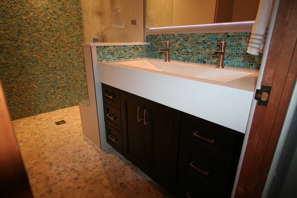 Inspiration för ett mellanstort funkis en-suite badrum, med ett avlångt handfat, luckor med infälld panel, skåp i mörkt trä, bänkskiva i akrylsten, en öppen dusch, en toalettstol med hel cisternkåpa, flerfärgad kakel, stenkakel, beige väggar och mosaikgolv