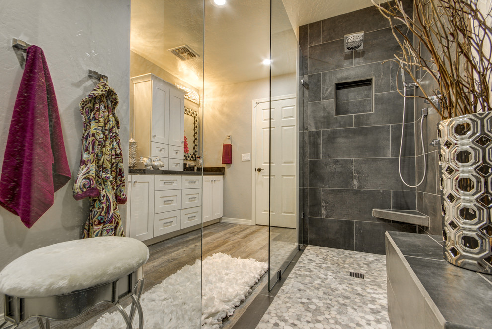 Cette image montre une grande salle de bain principale design avec un placard à porte shaker, des portes de placard blanches, une douche ouverte, un carrelage gris, des carreaux de béton, un mur gris, un sol en carrelage de porcelaine, un lavabo encastré et un plan de toilette en quartz.