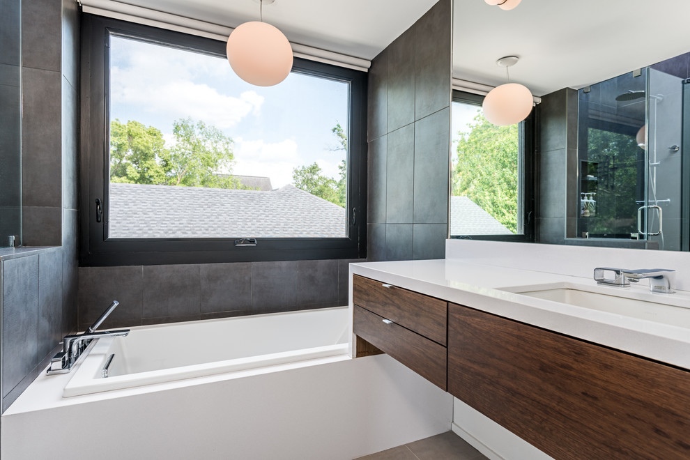 На фото: ванная комната в современном стиле с врезной раковиной, плоскими фасадами, темными деревянными фасадами и серой плиткой с