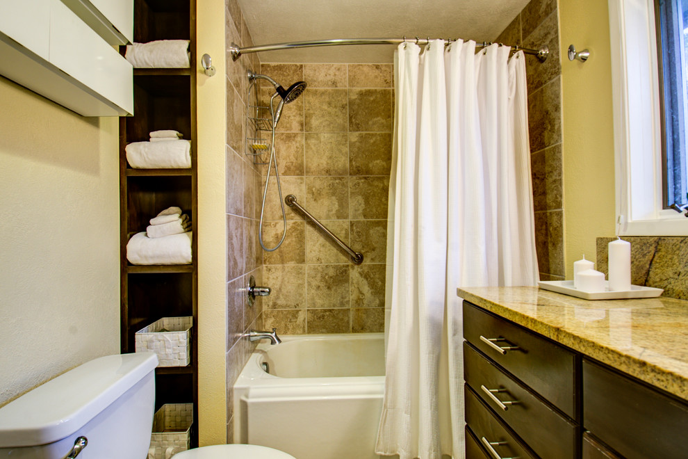Esempio di una piccola stanza da bagno con lavabo sottopiano, ante con riquadro incassato, ante in legno bruno, vasca ad alcova, piastrelle beige, piastrelle in ceramica, pareti gialle e pavimento con piastrelle in ceramica