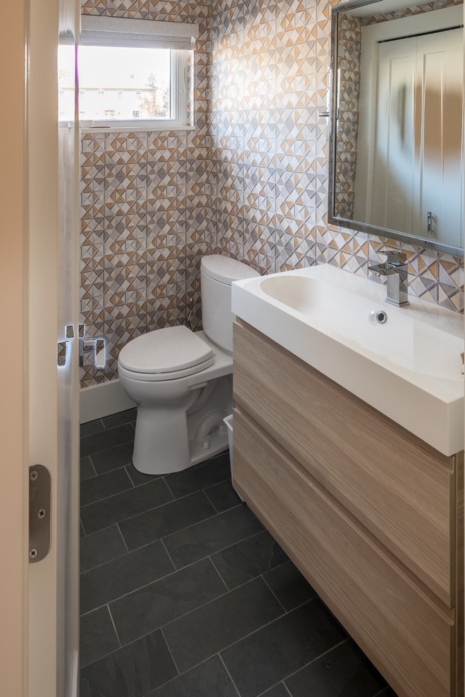 Foto di una piccola stanza da bagno con doccia minimal con ante lisce, ante in legno chiaro, WC monopezzo, pareti beige, pavimento in ardesia, lavabo rettangolare, top in quarzite e pavimento nero