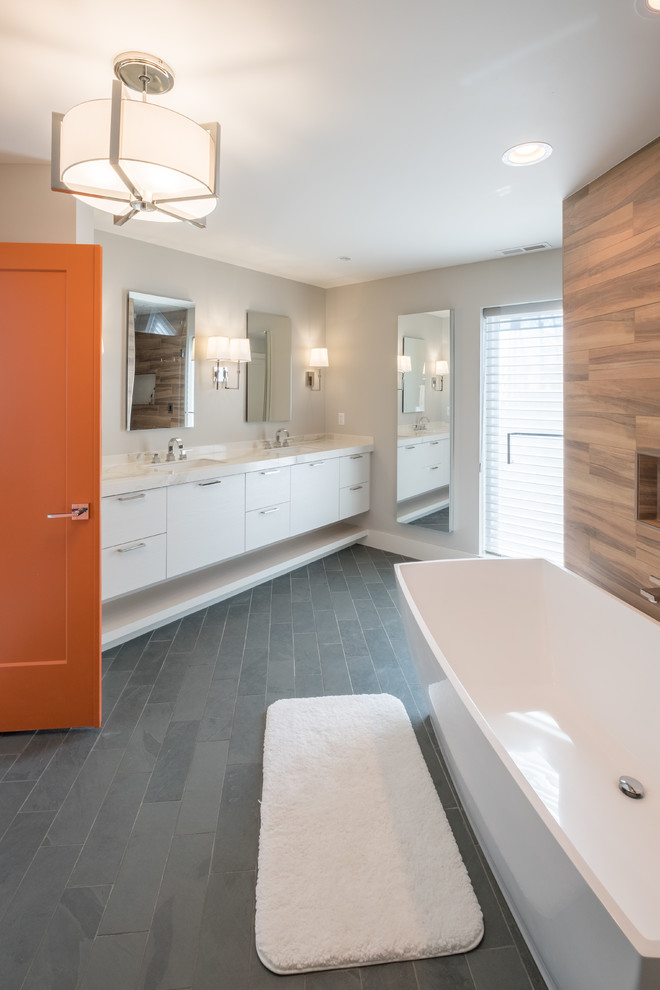 Пример оригинального дизайна: большая главная ванная комната в стиле модернизм с плоскими фасадами, белыми фасадами, отдельно стоящей ванной, серыми стенами, полом из сланца, врезной раковиной, столешницей из кварцита, угловым душем, коричневой плиткой, керамогранитной плиткой, серым полом и душем с распашными дверями