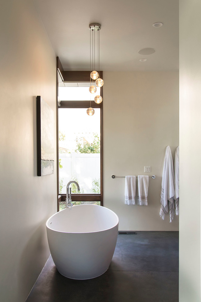 Design ideas for a medium sized modern ensuite bathroom in Salt Lake City with a vessel sink, flat-panel cabinets, dark wood cabinets, engineered stone worktops, a freestanding bath, a built-in shower, a one-piece toilet, white tiles, porcelain tiles, white walls and concrete flooring.